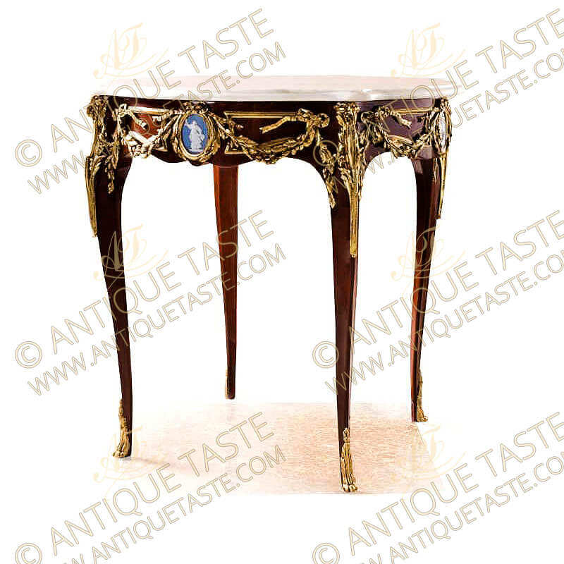 French Louis XV style ormolu-mounted mahogany inlaid Herculaneum Wedgwood Jasperware plaque center table after the model by Francois Linke, the eared circular marble top above astonishing a frieze ornamented with falling ribbon-tied laurel festoons centered by an oval medallion with a ribbon-tied laurel-cast wreath framing a light blue allegorical Herculaneum Wedgwood Jasperware plaque, the table is raised on cabriole legs each surmounted by a scrolling acanthus clasp, and put down on acanthus-cast paw feet, the fine piece is available with a central ormolu plaque of a playful cherub